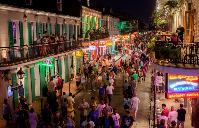 people wander through new orlleans most famous street during a light summer\'s evening.